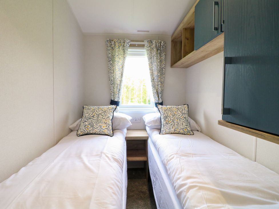 A bedroom with two single beds and a window at Red Kite Lodge in Coalville