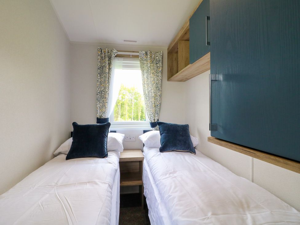 A bedroom with two single beds and a window at Red Kite Lodge in Coalville