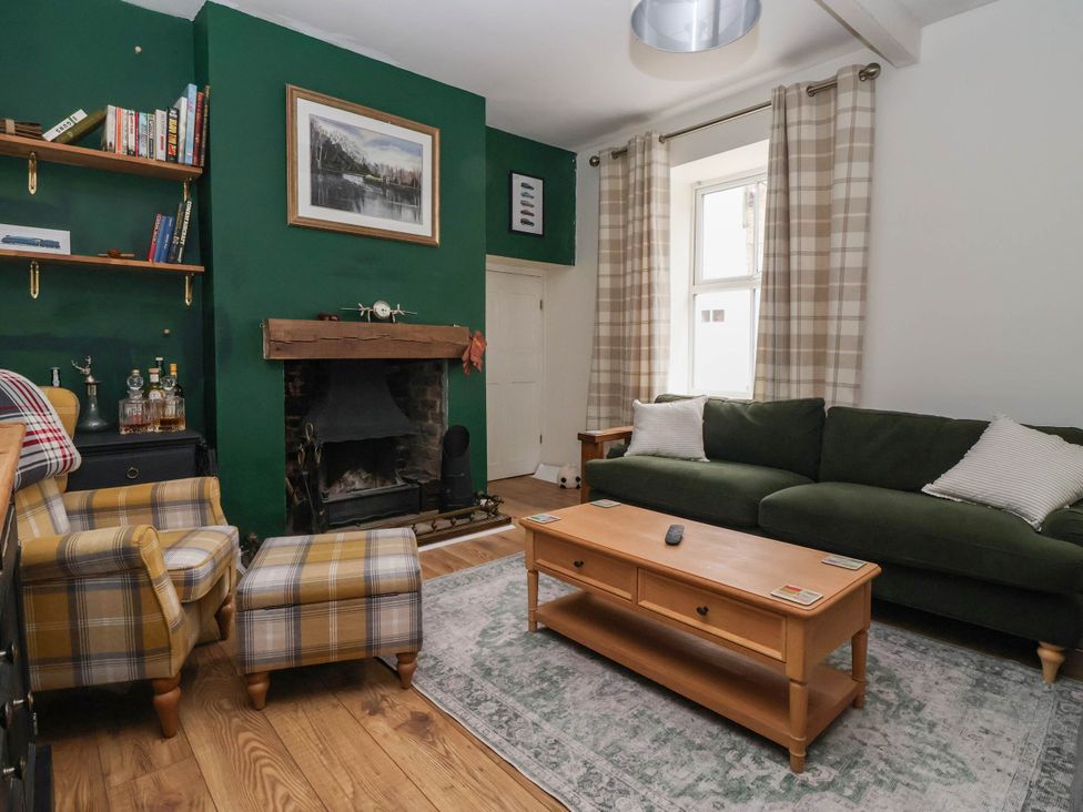 A living room with a green wall and a sofa at Bowdery in Harrogate