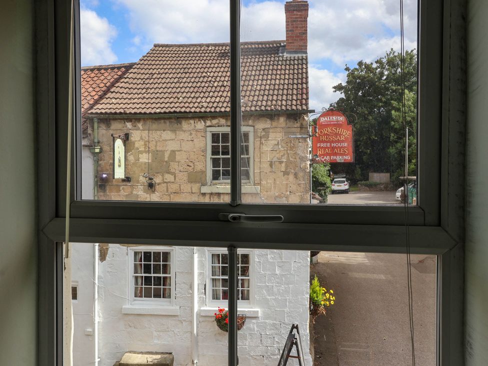 A view of a house and a sign from a window at Bowdery in Harrogate