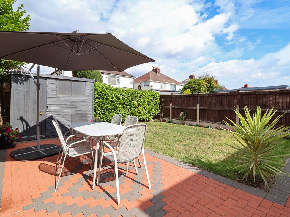 A garden with a table and chairs under an umbrella at Laburnum house Ellesmere Port
