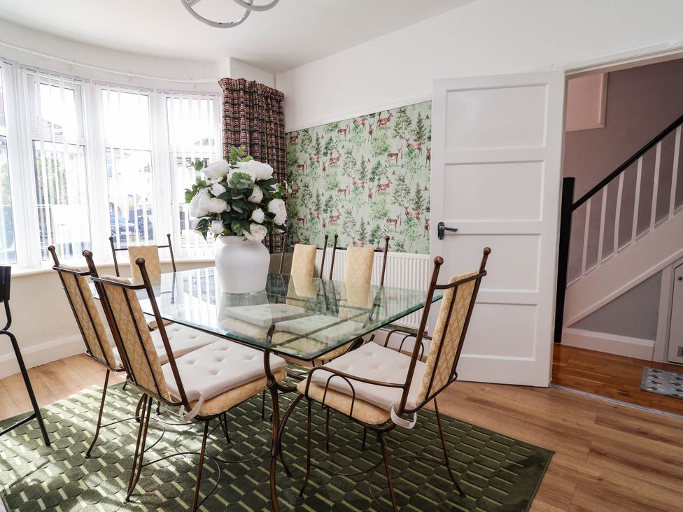 A dining room with a glass table and chairs at Laburnum house Ellesmere Port