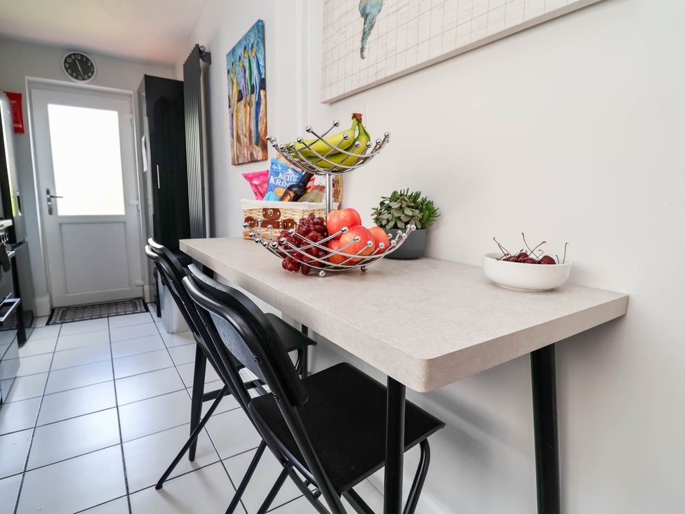 A kitchen with a table and fruit bowls at Laburnum house in Ellesmere Port