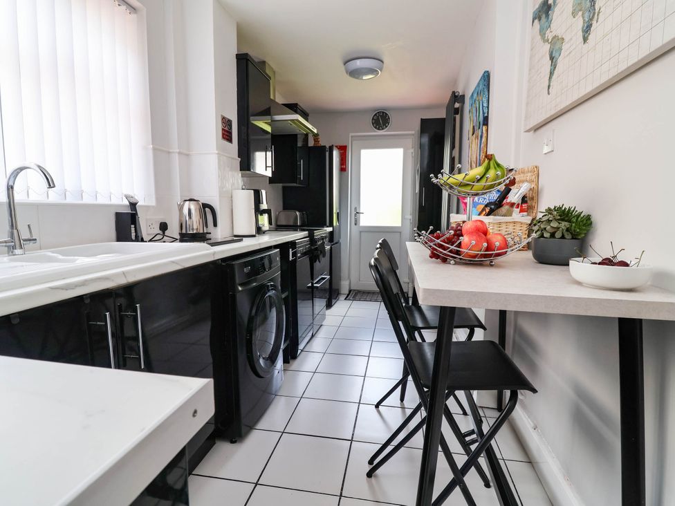A kitchen with appliances and a fruit bowl at Laburnum house in Ellesmere Port