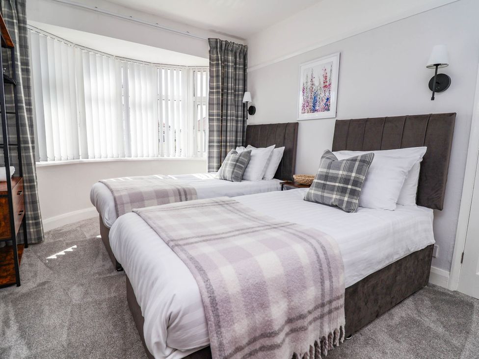 A bedroom with two beds and window at Laburnum house in Ellesmere Port