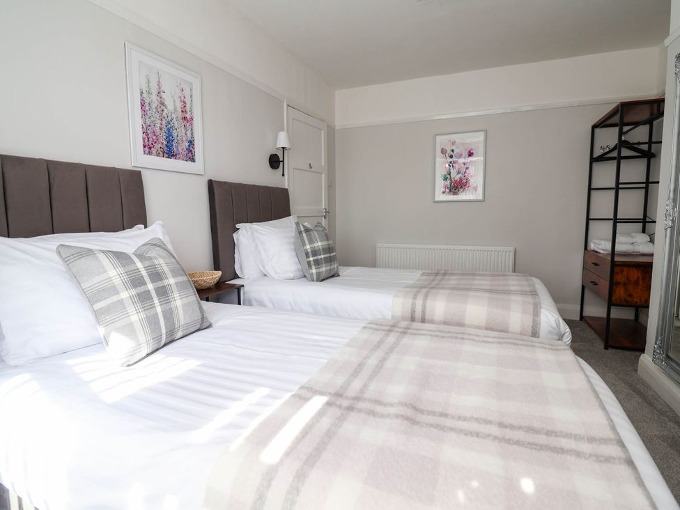 A bedroom with two beds and artwork at Laburnum house Ellesmere Port