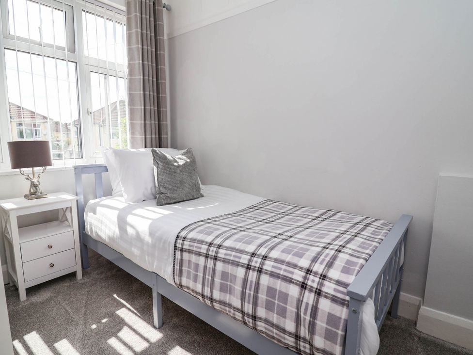 A bedroom with a single bed and a lamp on a nightstand at Laburnum house Ellesmere Port
