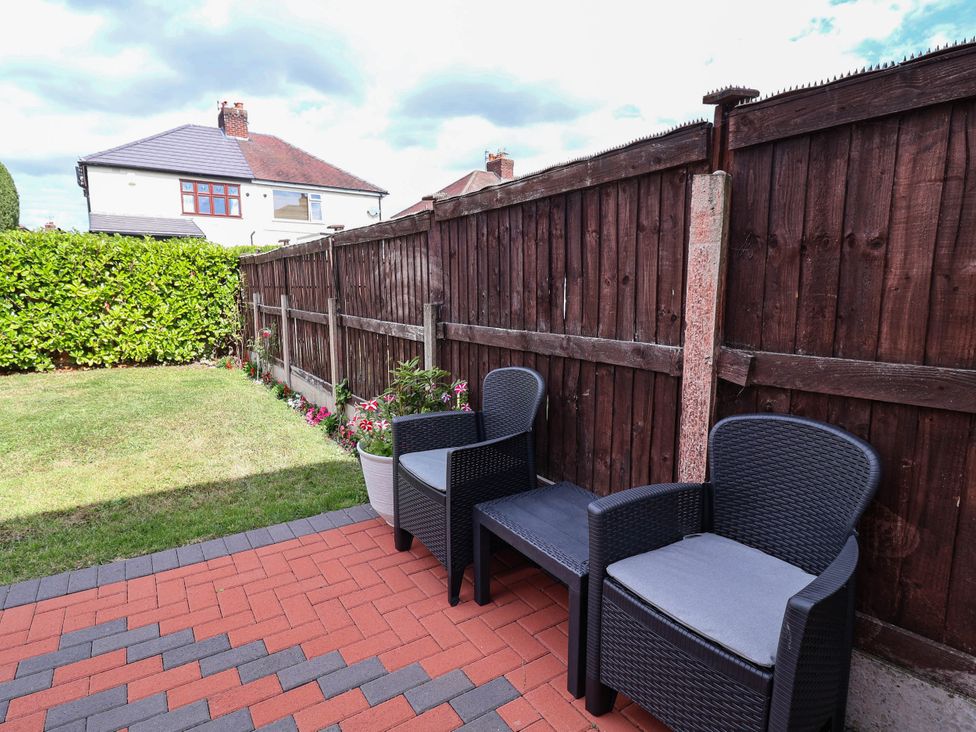 A garden with chairs and a fence at Laburnum house Ellesmere Port