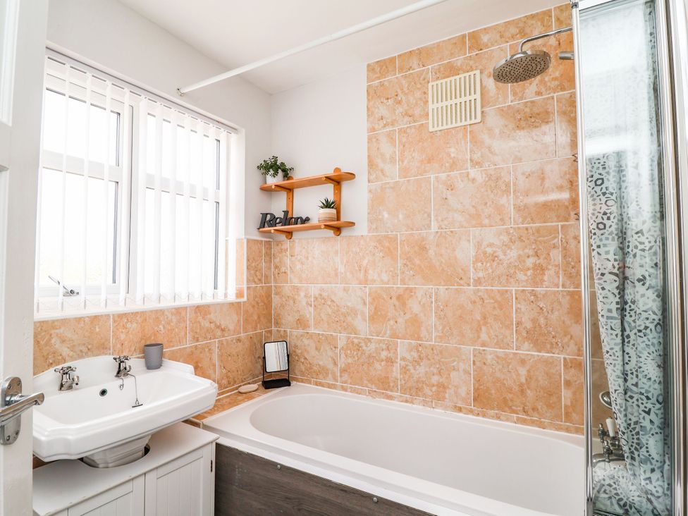 A bathroom with a bathtub and sink at Laburnum House in Ellesmere Port