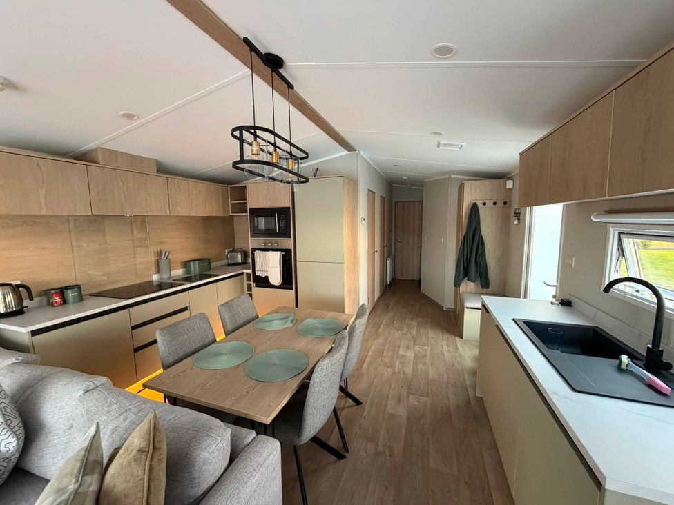 A kitchen with dining area and appliances at Haggerston Castle - Lakeside Retreat in Berwick-upon-Tweed