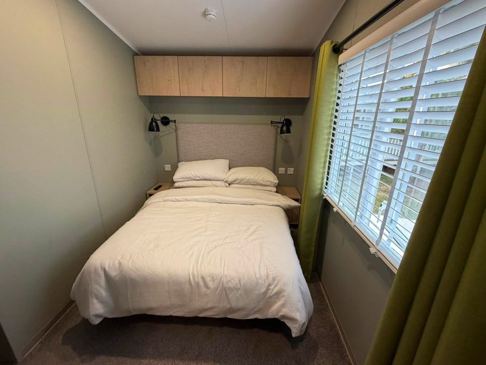 A bedroom with a bed and window at Haggerston Castle - Lakeside Retreat Berwick-upon-Tweed