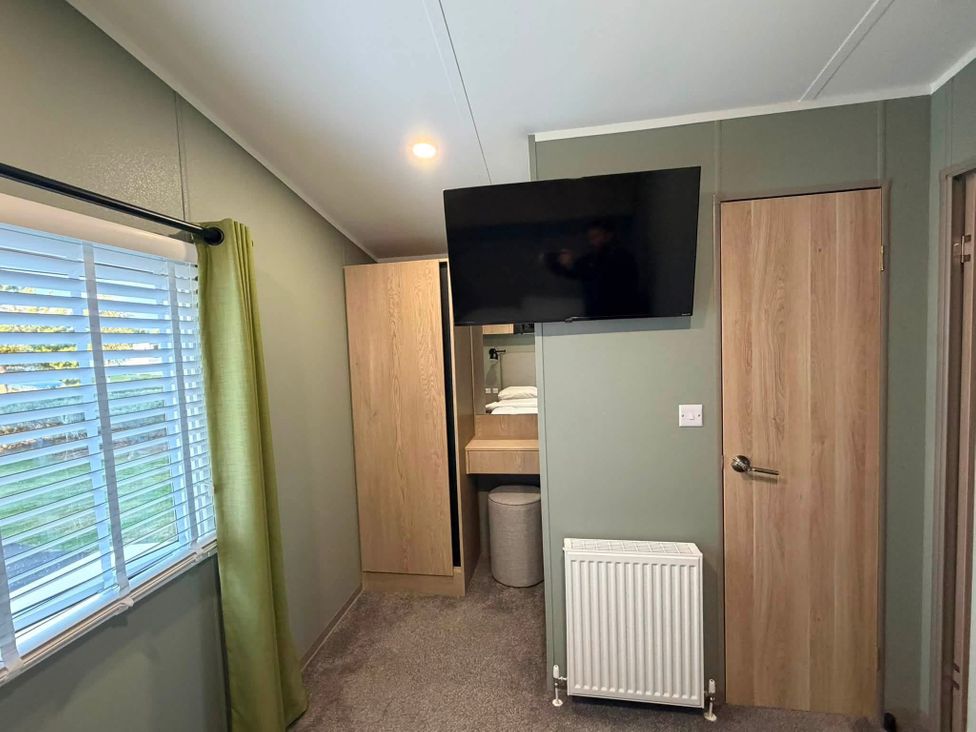 A bedroom with a television and wardrobe at Haggerston Castle - Lakeside Retreat, Berwick-upon-Tweed