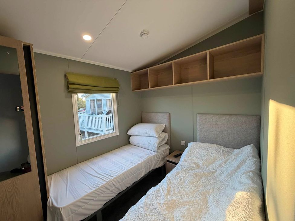 A bedroom with two beds and a window at Haggerston Castle - Lakeside Retreat Berwick-upon-Tweed