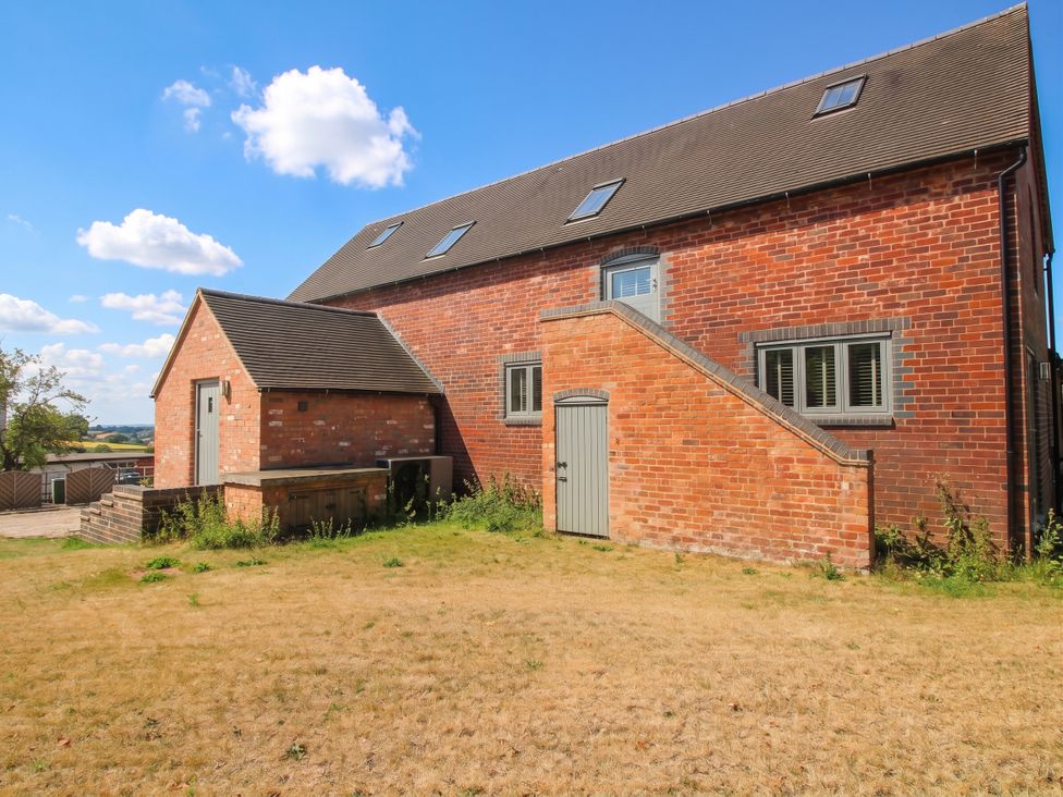 A brick house with windows and a door at The Hayloft in Birmingham