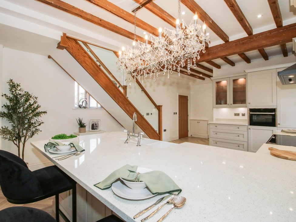 A kitchen with a chandelier and kitchen island at The Hayloft in Birmingham