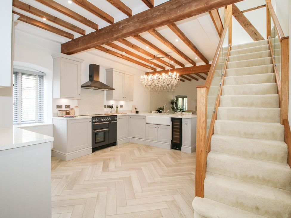 A kitchen with a staircase and a chandelier at The Hayloft in Birmingham