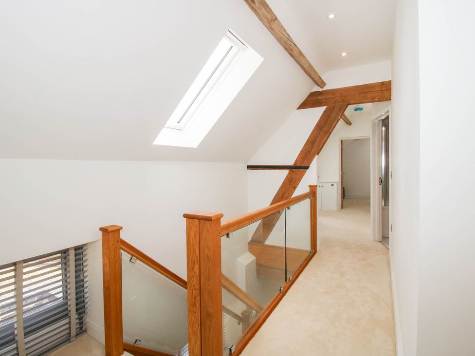 A hallway with a staircase and skylight at The Hayloft in Birmingham