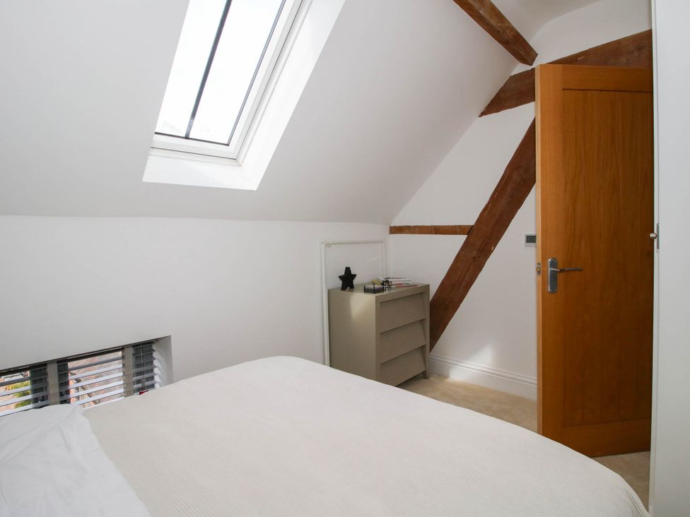 A bedroom with a bed and shelf at The Hayloft in Birmingham