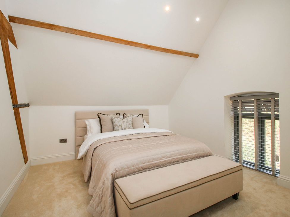 A bedroom with a bed and window at The Hayloft in Birmingham