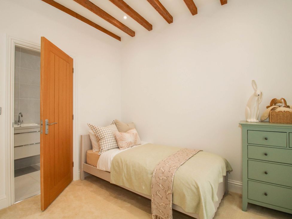 A bedroom with a bed and a bathroom door at The Hayloft in Birmingham