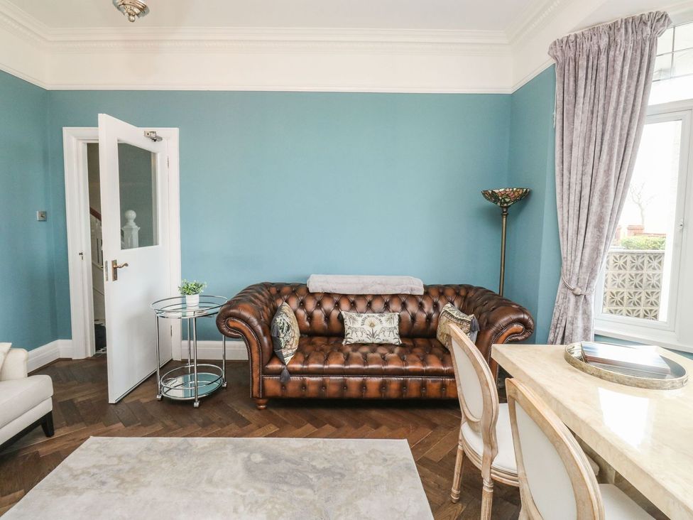 A living room with a leather sofa and dining furniture at Russell House in Paignton