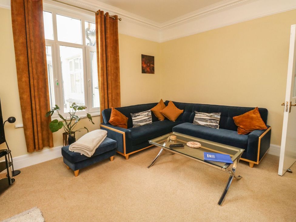A living room with a sofa and a glass table at Russell House in Paignton