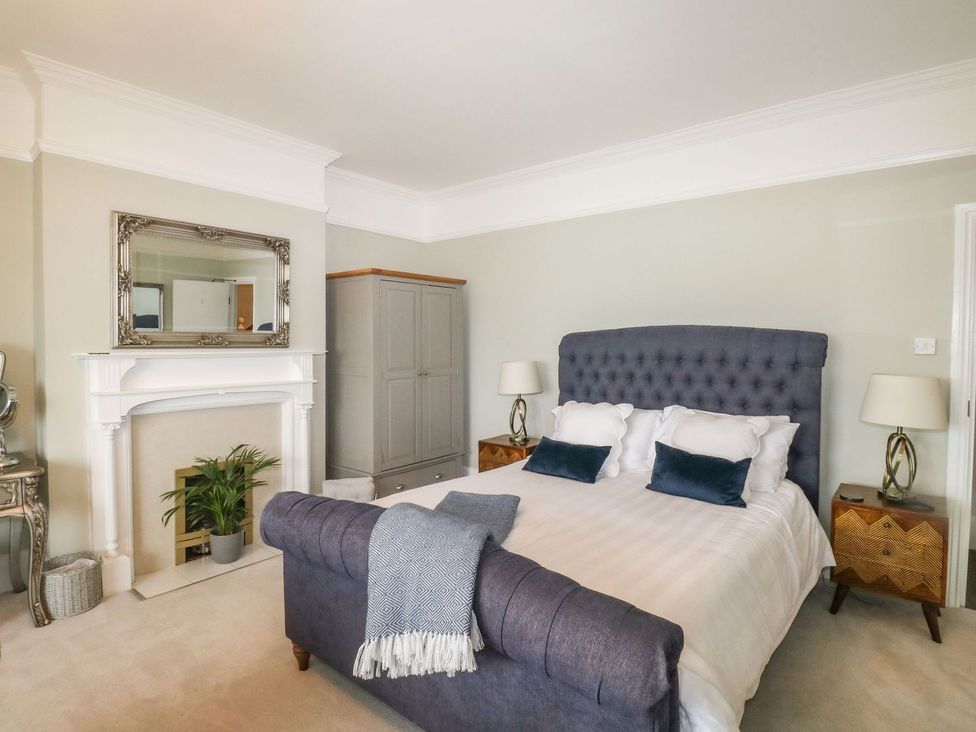 A bedroom with a bed and mirrors at Russell House in Paignton