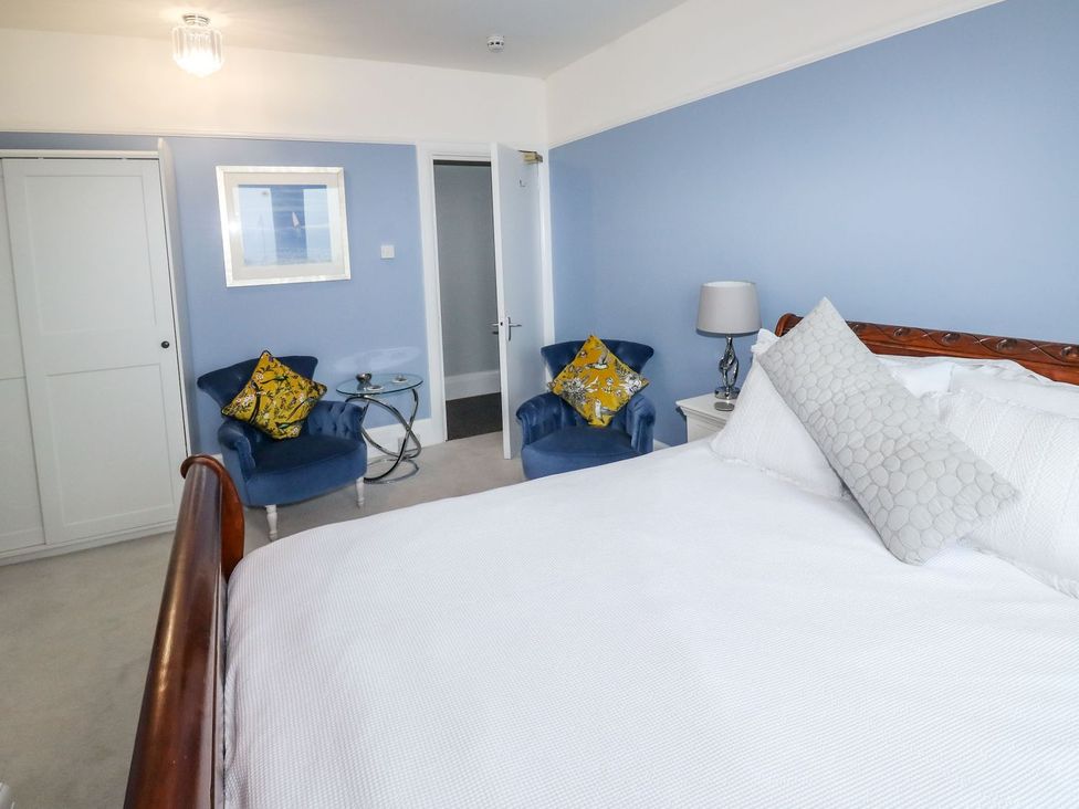 A bedroom with a bed and seating area at Russell House in Paignton