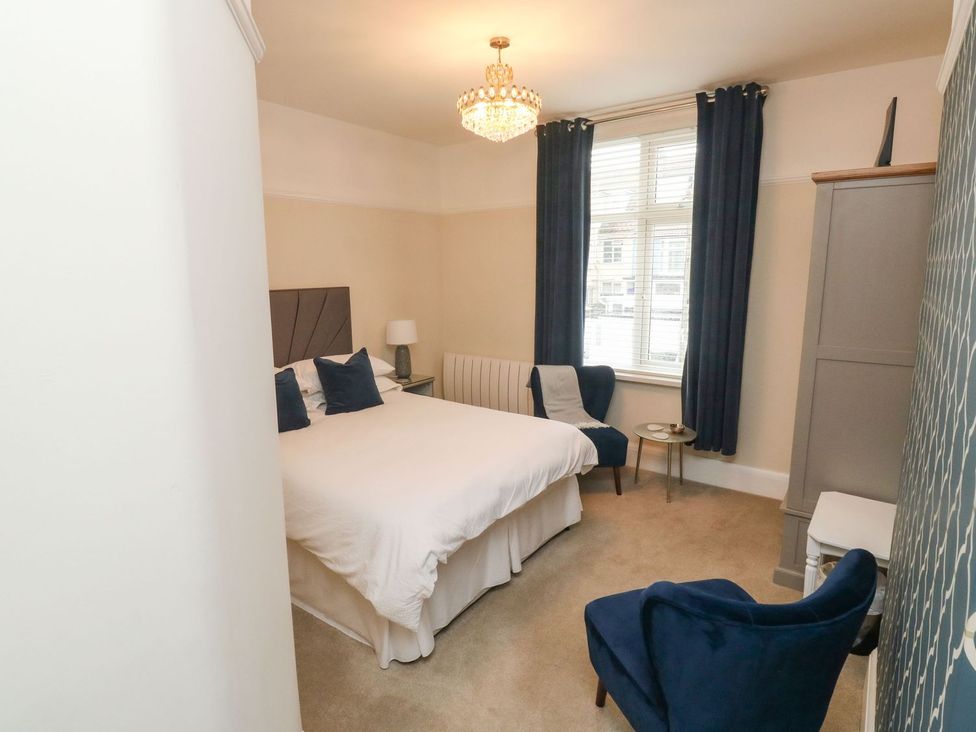 A bedroom with a bed and a chair at Russell House in Paignton