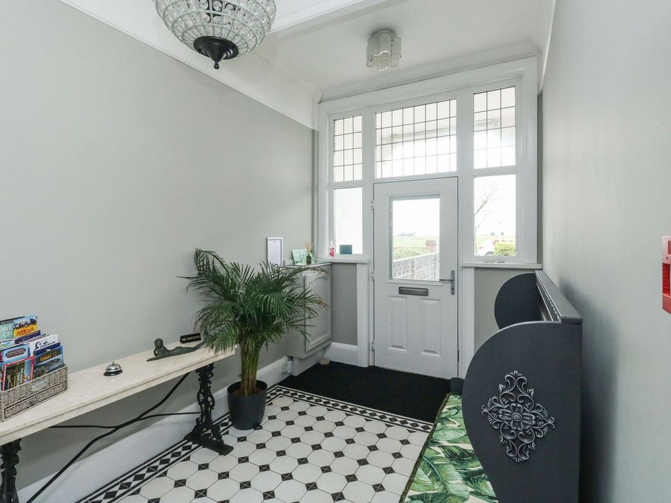 A hallway with a console table and a plant at Russell House in Paignton