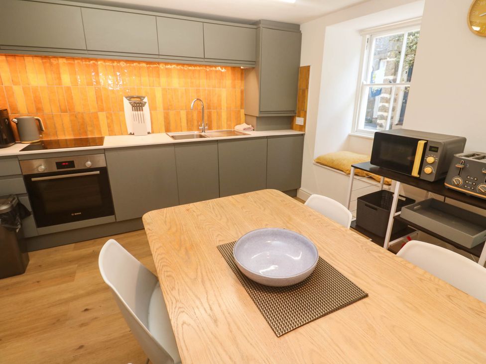 A kitchen with a dining table and chairs at Top Deck in St. Ives