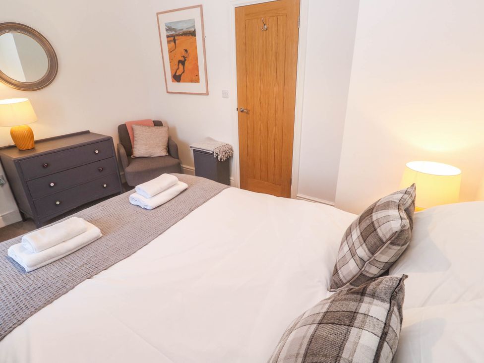 A bedroom with a bed and dresser at Top Deck in St. Ives