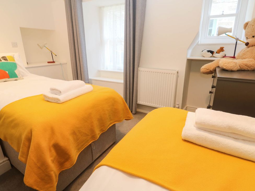 A bedroom with two beds and a teddy bear at Top Deck in St. Ives