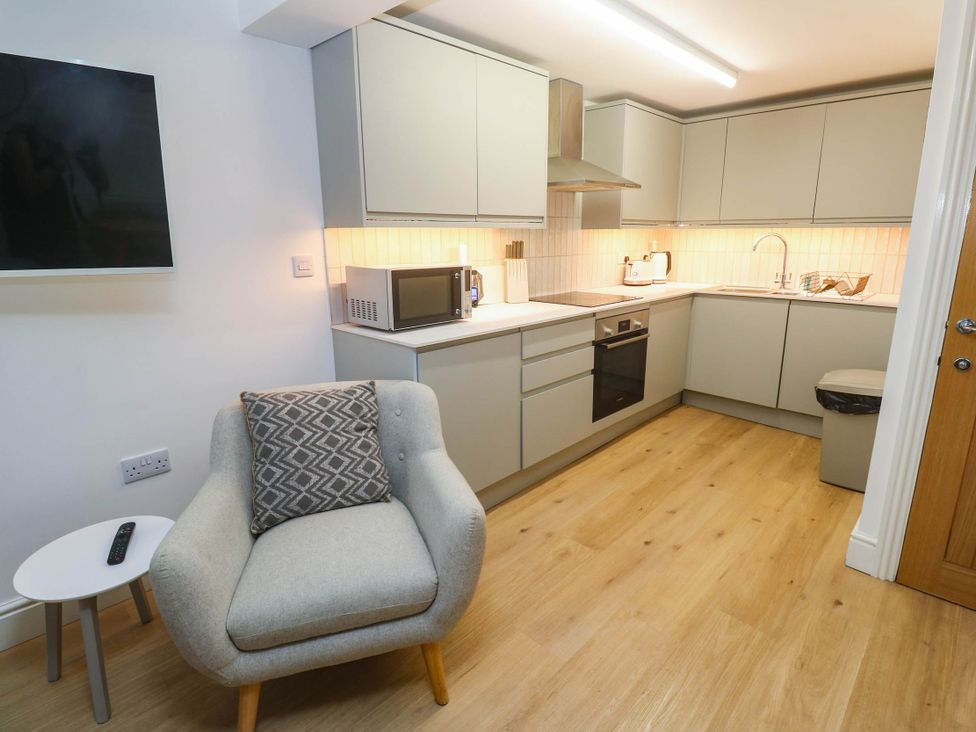 A kitchen with modern appliances and furniture at The Cabin in St Ives