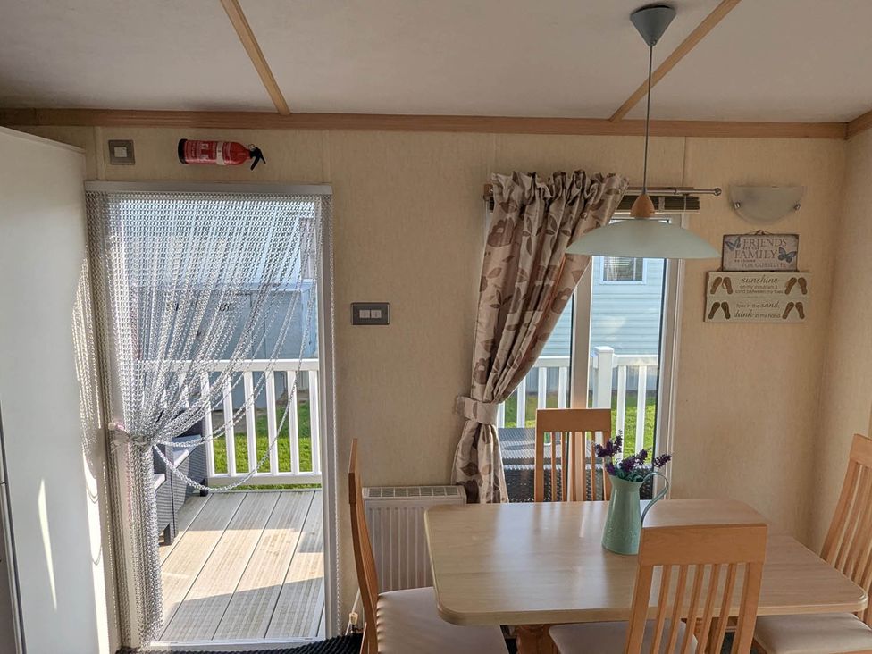 A dining room with a table and chairs at Beachcomber Cabin Dog Friendly Anderby Creek Lincolnshire