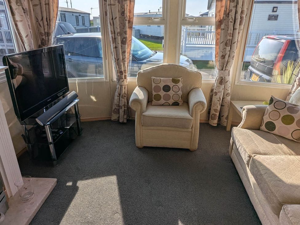 A living room with a television and seating at Beachcomber Cabin Dog Friendly Anderby Creek, Lincolnshire