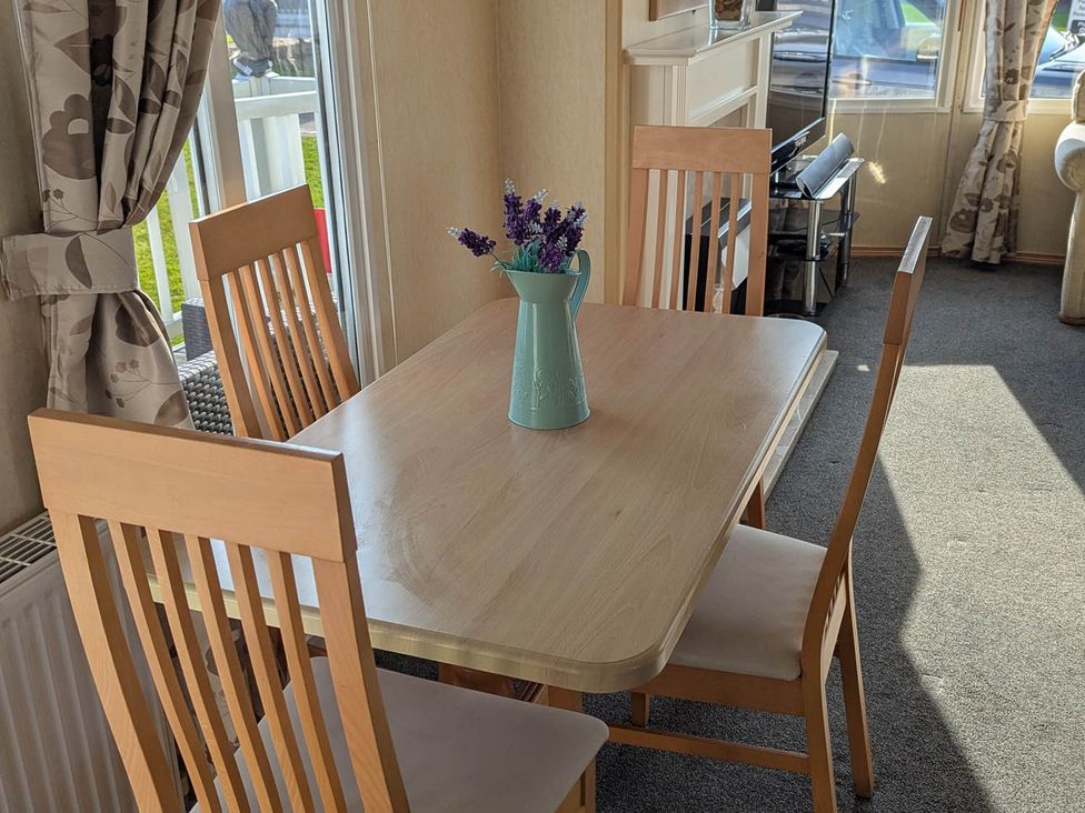 A dining table with chairs and a vase at Beachcomber Cabin Dog Friendly Anderby Creek Lincolnshire