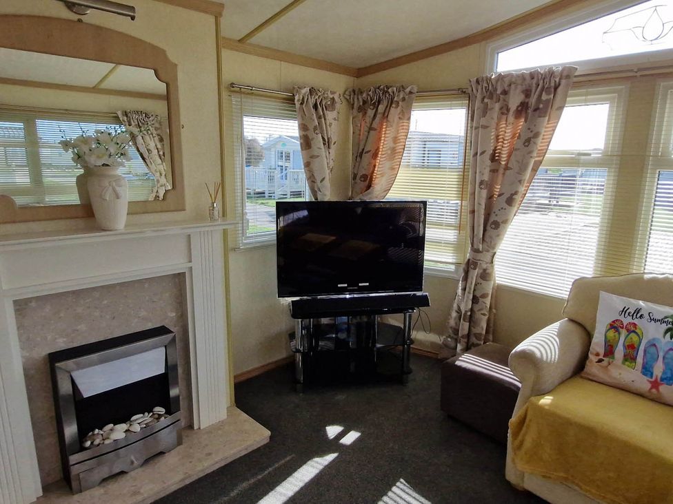 A living room with a television and fireplace at Beachcomber Cabin Dog Friendly Anderby Creek Lincolnshire