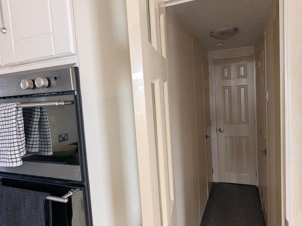 A kitchen with an oven and a corridor at Beachcomber Cabin Dog Friendly Anderby Creek Lincolnshire
