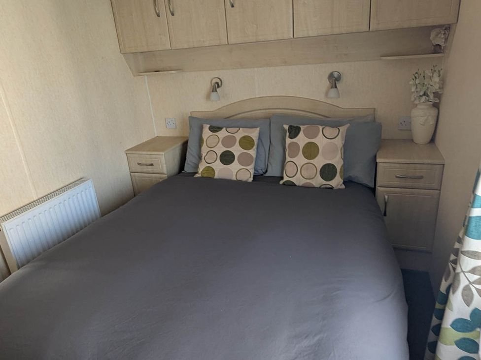 A bedroom with a bed and bedside table at Beachcomber Cabin Dog Friendly Anderby Creek Lincolnshire