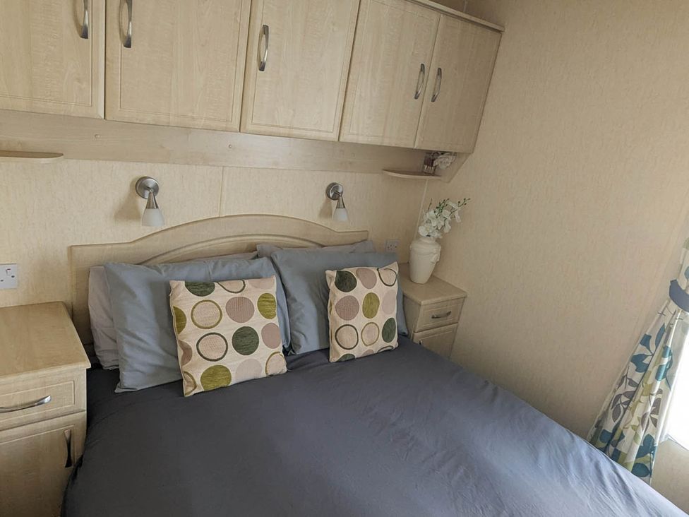A bedroom with a bed and lamps at Beachcomber Cabin Dog Friendly Anderby Creek Lincolnshire