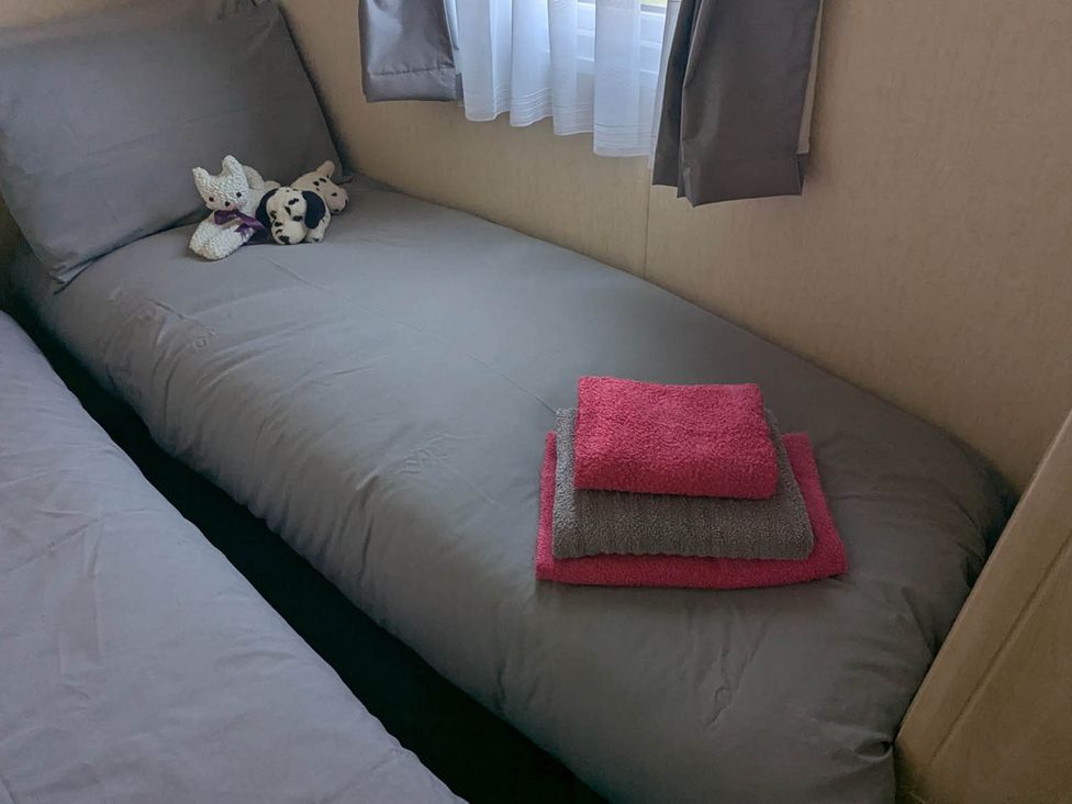 A bedroom with a bed and towels at Beachcomber Cabin Dog Friendly Anderby Creek Lincolnshire