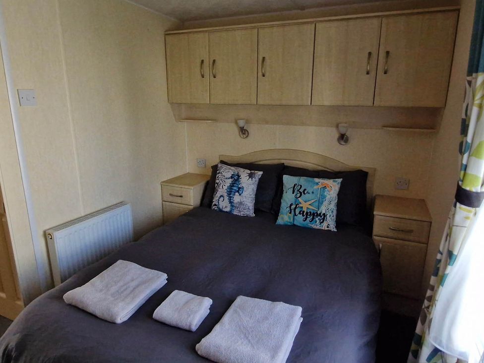 A bedroom with a bed and pillows at Beachcomber Cabin Dog Friendly Anderby Creek Lincolnshire