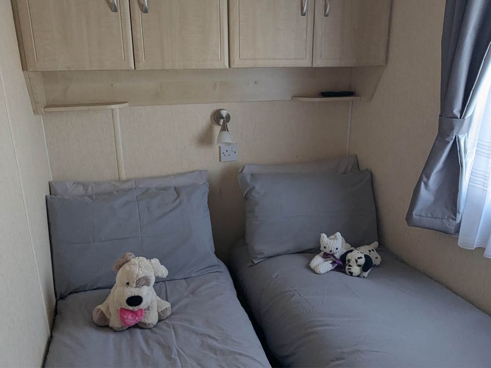 A bedroom with two beds and stuffed toys at Beachcomber Cabin Dog Friendly Anderby Creek in Lincolnshire