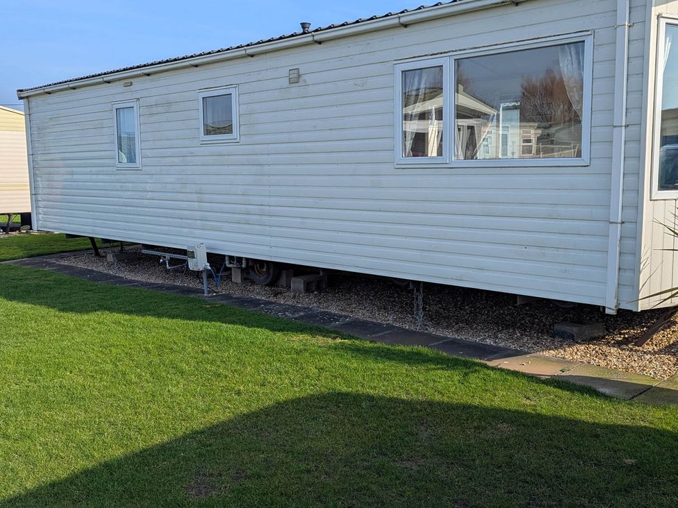 A mobile home with windows and grass at Beachcomber Cabin Dog Friendly Anderby Creek Lincolnshire