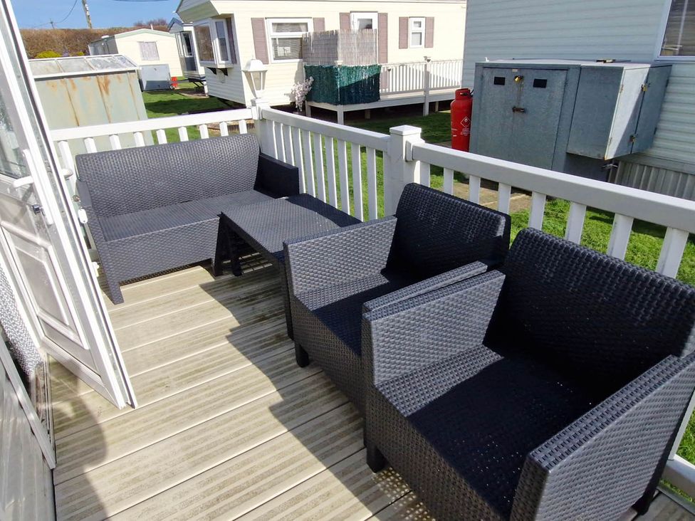 A deck area with outdoor furniture at Beachcomber Cabin Dog Friendly Anderby Creek Lincolnshire