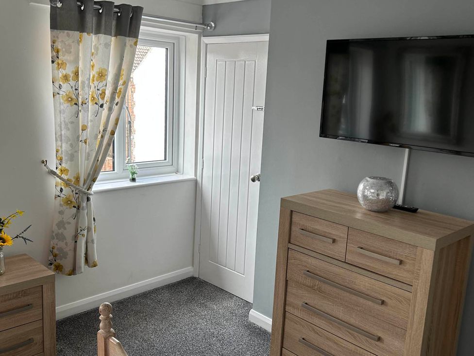 A bedroom with a window and television at the property location