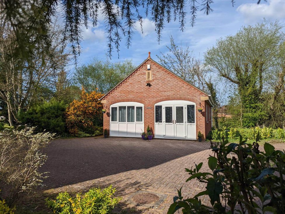 A brick building with double doors and windows in an outdoor area