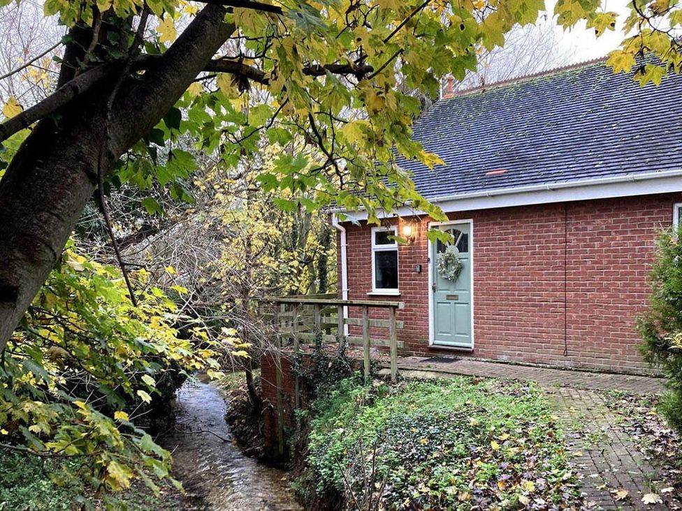 A house with a door and small bridge near a stream