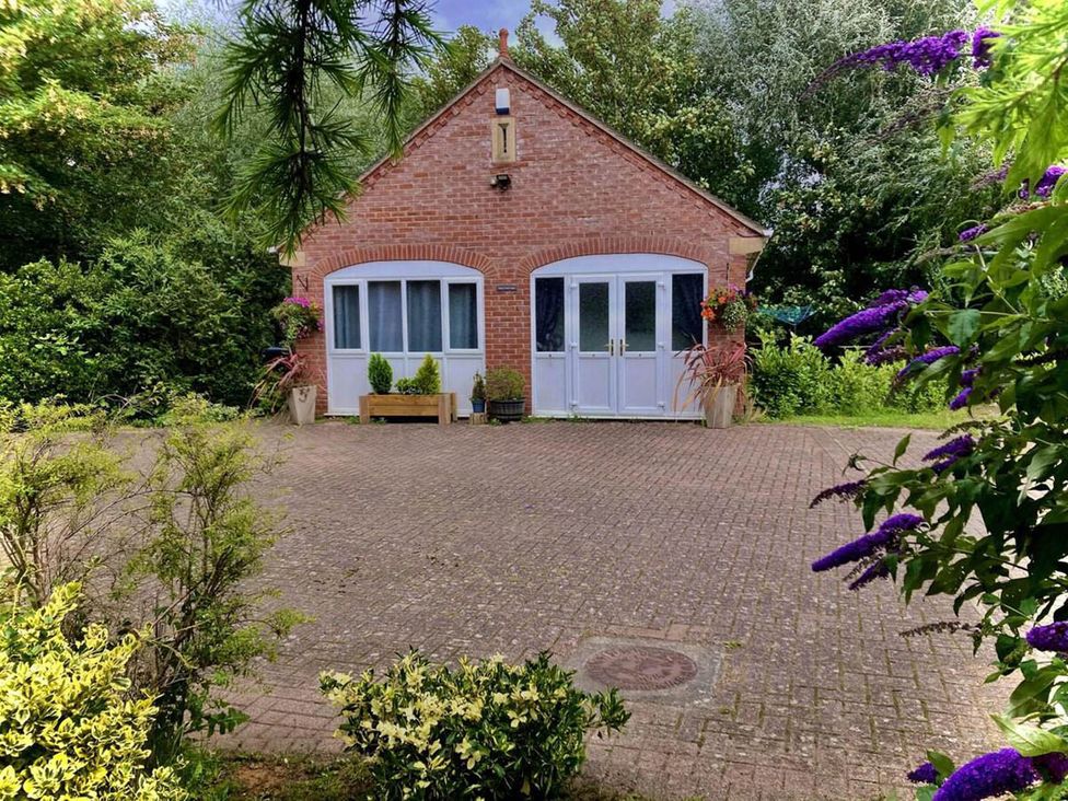 A brick house with a garden and a paved area in front